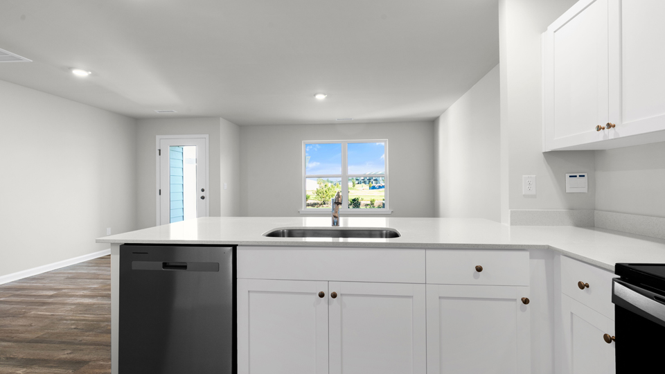 kitchen with quartz counters, kitchen island, pantry, stainless steel appliances