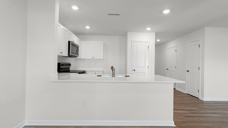 kitchen with quartz counters, kitchen island, pantry, stainless steel appliances