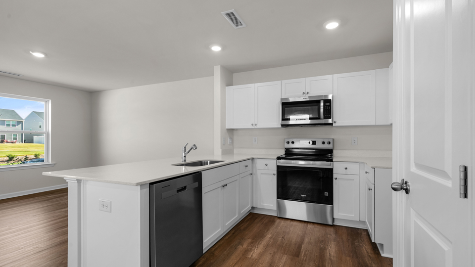 kitchen with quartz counters, kitchen island, pantry, stainless steel appliances