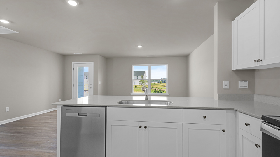 kitchen with quartz counters, kitchen island, pantry, stainless steel appliances