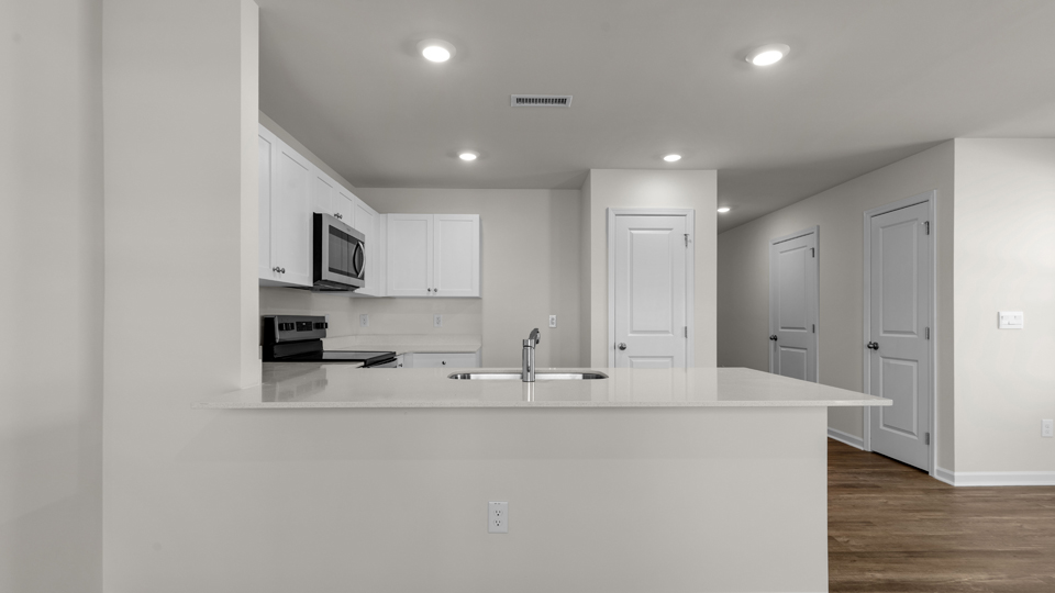 kitchen with quartz counters, kitchen island, pantry, stainless steel appliances