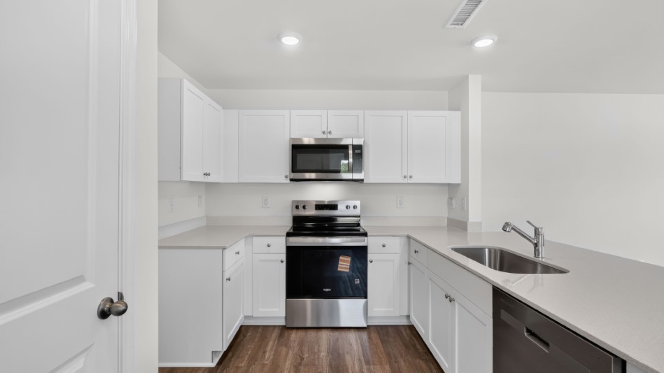 kitchen with quartz counters, kitchen peninsula, pantry, stainless steel appliances