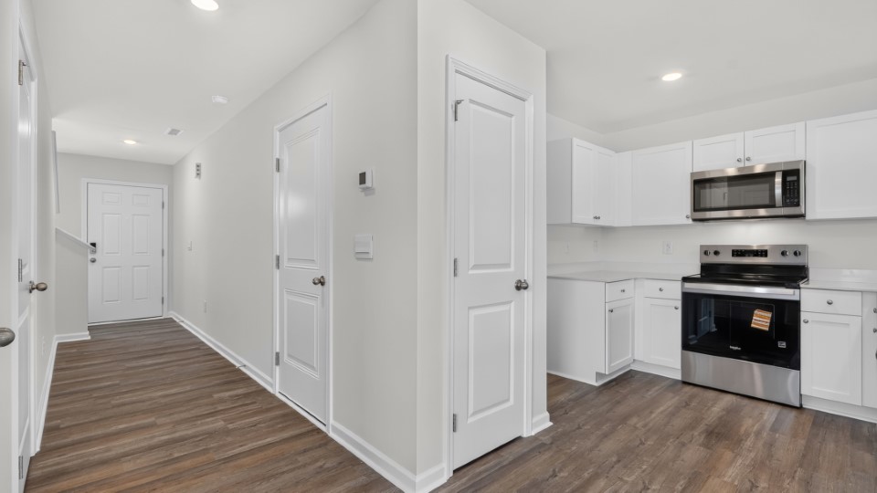 kitchen with quartz counters, kitchen peninsula, pantry, stainless steel appliances