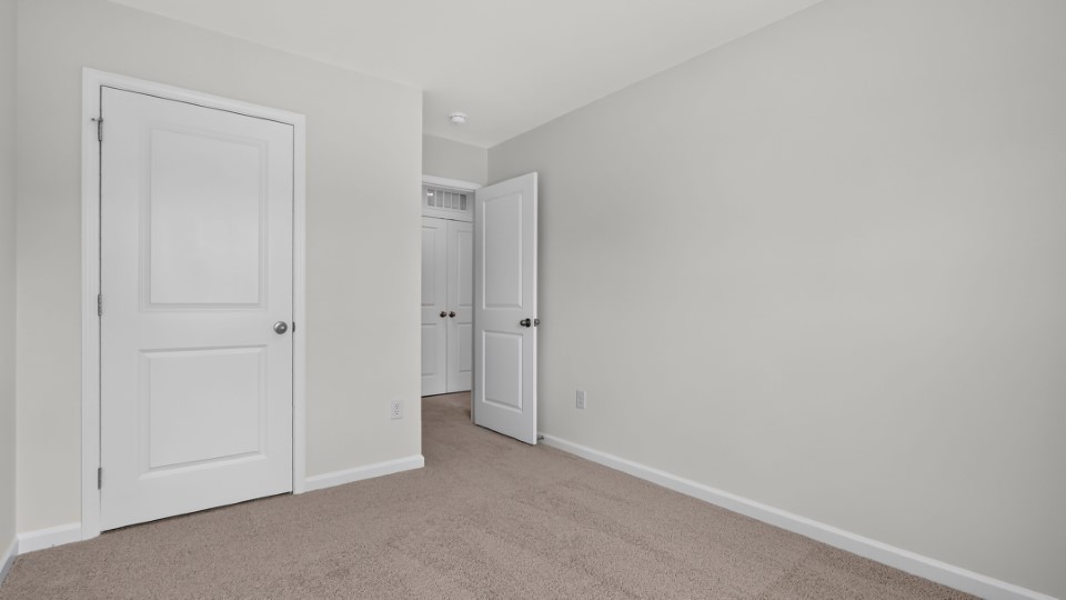 secondary bedroom with window and closet, carpeting