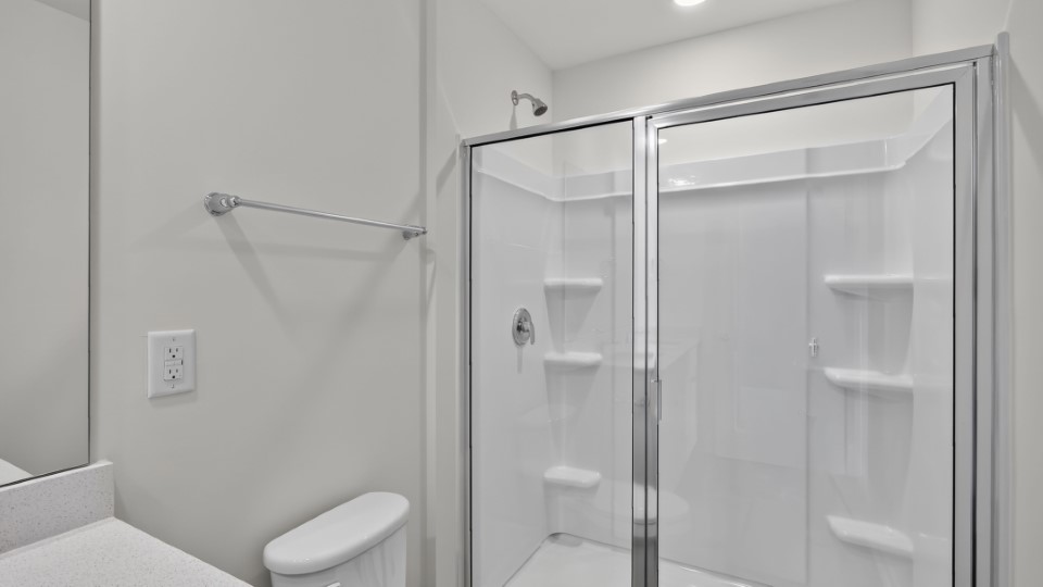 primary bathroom with walk in shower and dual vanity sinks