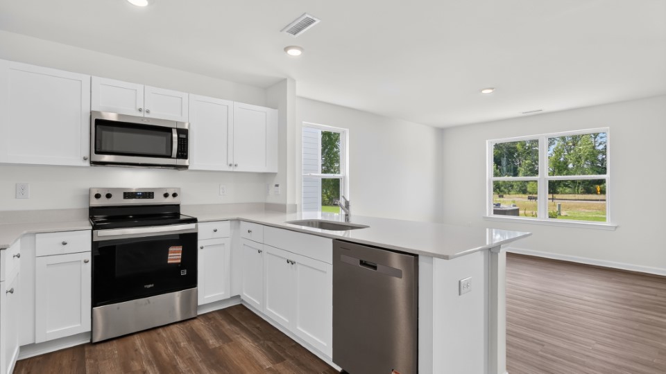 kitchen with quartz counters, kitchen island, pantry, stainless steel appliances