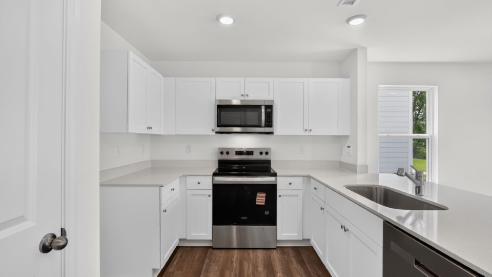 kitchen with quartz counters, kitchen island, pantry, stainless steel appliances