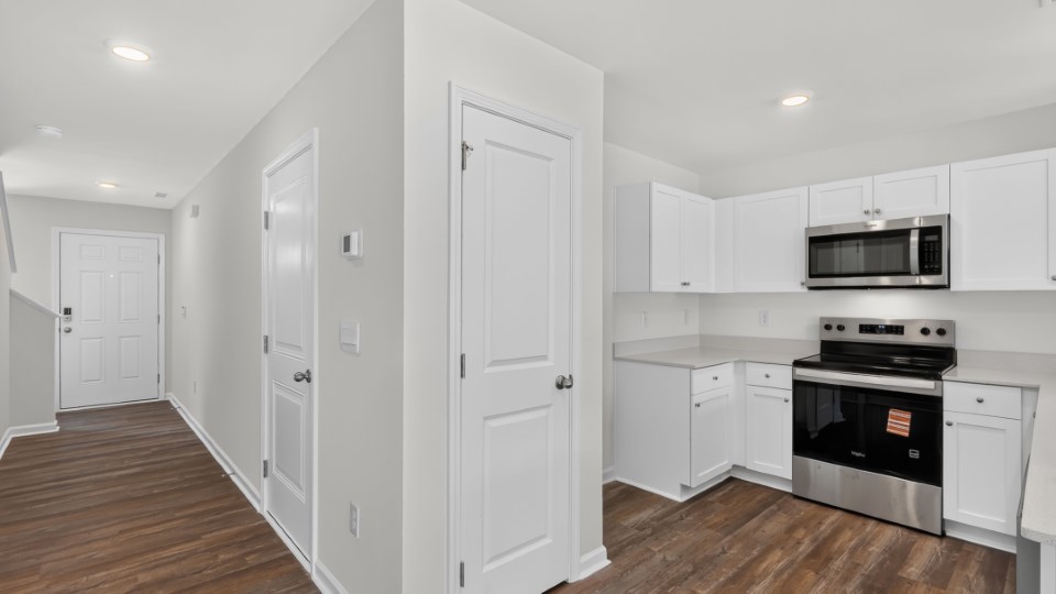 kitchen with quartz counters, kitchen island, pantry, stainless steel appliances