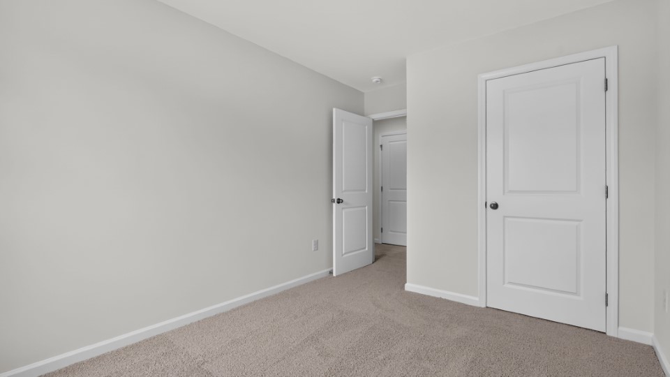 secondary bedroom with window and closet, carpeting