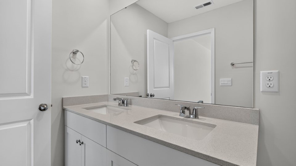 primary bathroom with walk in shower and dual vanity sinks