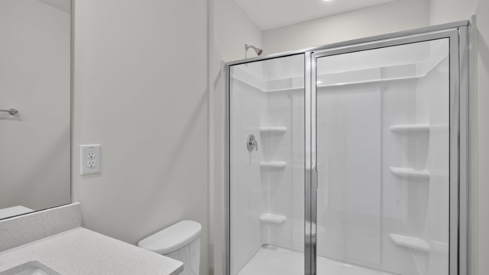 primary bathroom with walk in shower and dual vanity sinks