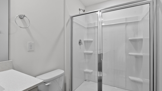 primary bathroom with walk in shower and dual vanity sinks
