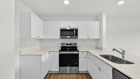 kitchen with quartz counters, kitchen peninsula, pantry, stainless steel appliances