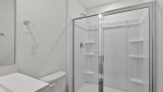 primary bathroom with walk in shower and dual vanity sinks