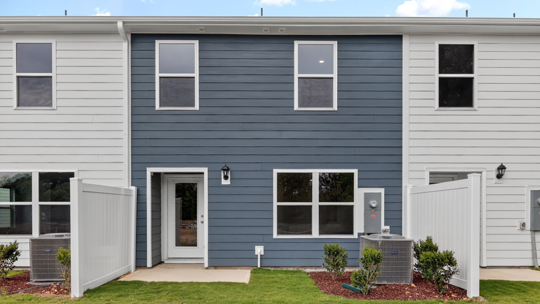 back exterior with blue siding and patio