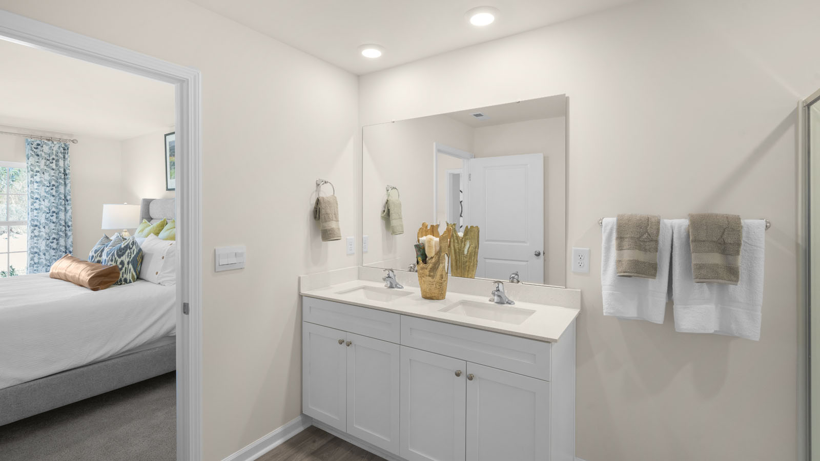 primary bathroom with walk in shower and dual vanity sinks