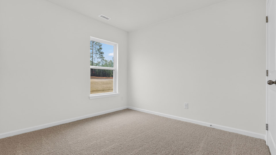 primary bedroom with two windows and carpeting, attached bath