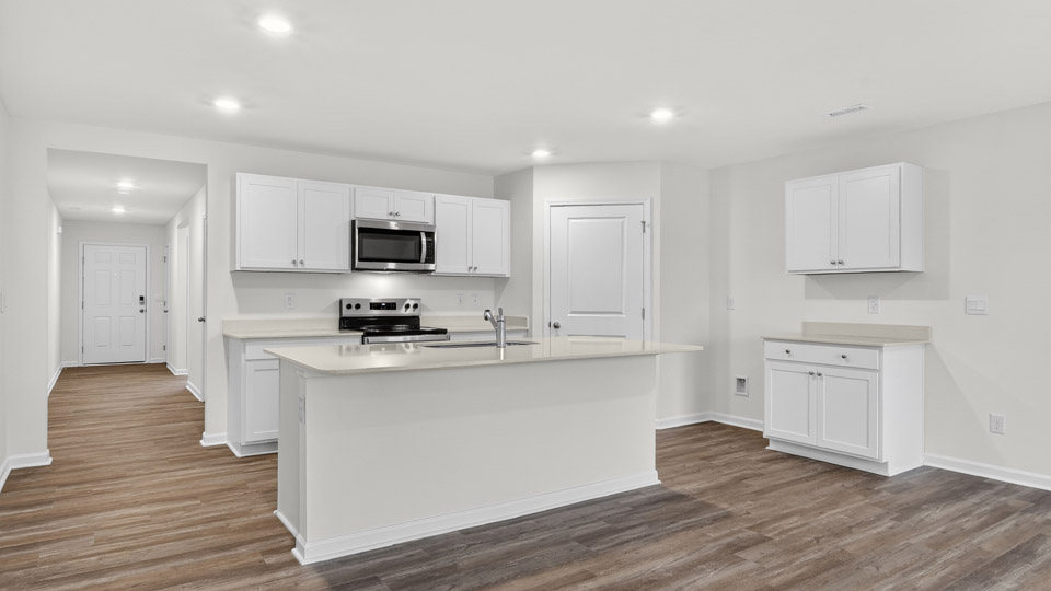 kitchen with quartz counters, kitchen island, pantry, stainless steel appliances