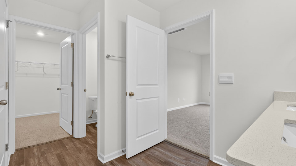 primary bathroom with walk in shower and dual vanity sinks