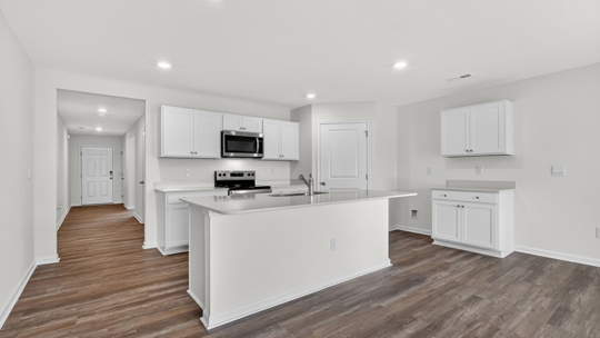 kitchen with white cabinets island and quartz countertops