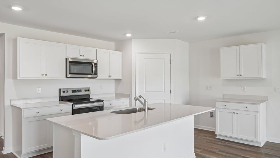 kitchen with white cabinets quartz countertops spacious island