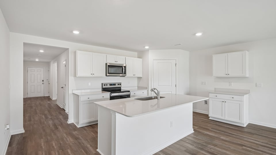 kitchen with quartz countertops white cabinets and spacious island