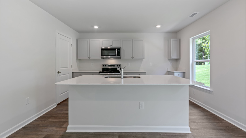 kitchen with quartz counters, kitchen island, pantry, stainless steel appliances