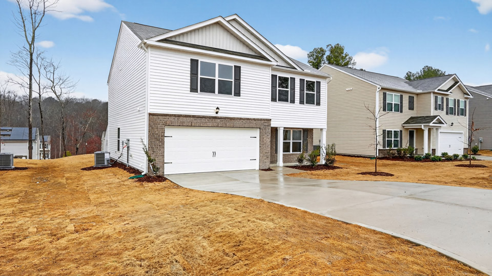 Two story home with white colored siding with a two car garage
