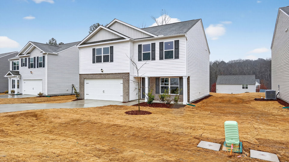 Two story home with white colored siding with a two car garage