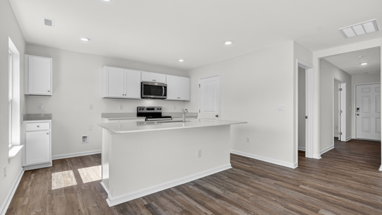 kitchen with white cabinets and island and quartz countertops