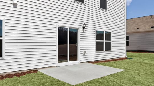 back of home with concrete patio
