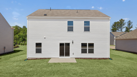 back of home with concrete patio