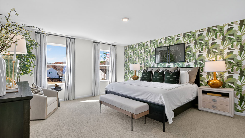 Primary bedroom with carpet floors and windows with access to the primary bathroom