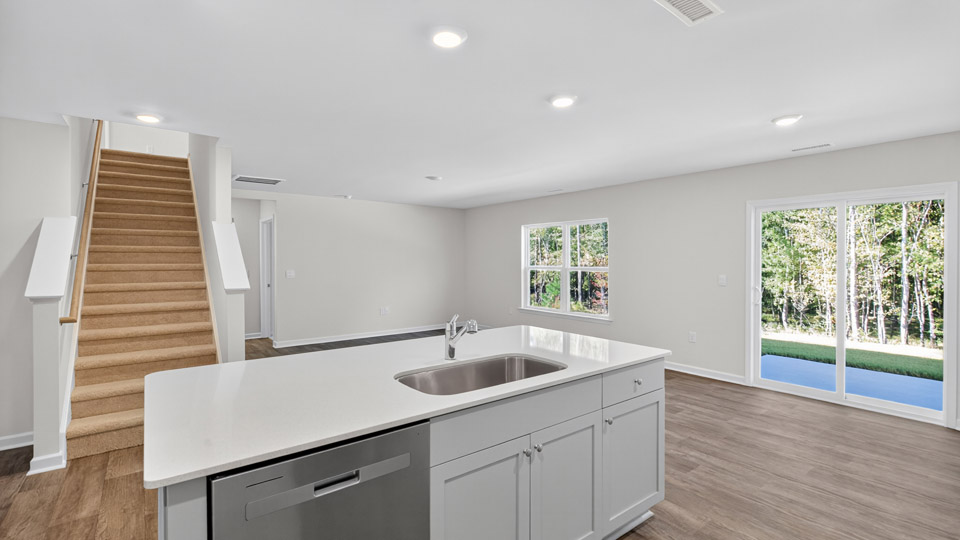 kitchen with quartz counters, kitchen island, pantry, stainless steel appliances