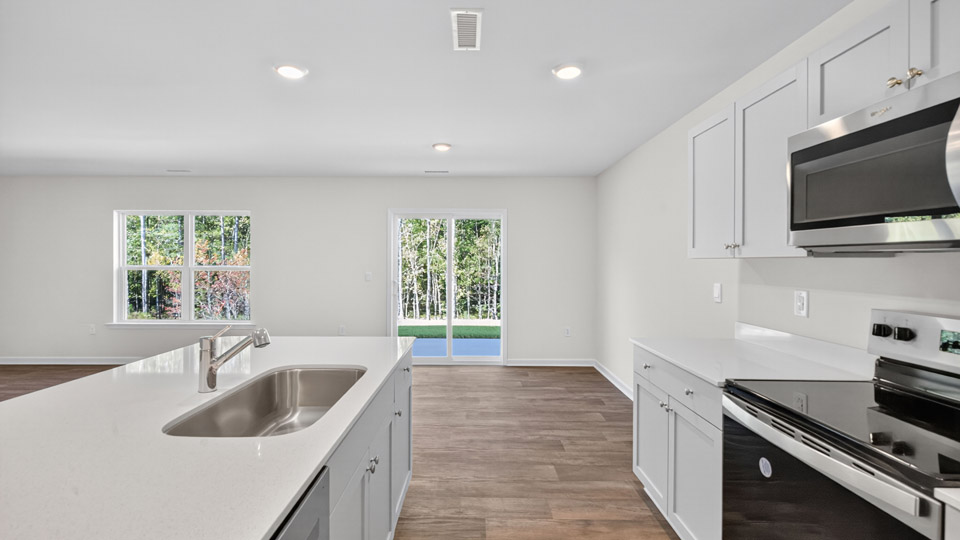 kitchen with quartz counters, kitchen island, pantry, stainless steel appliances