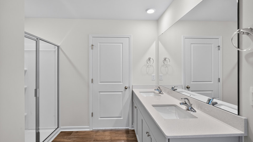 primary bathroom with walk in shower and dual vanity sinks