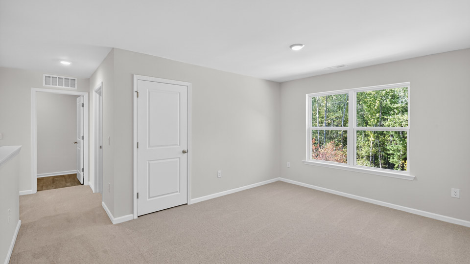 upstairs loft area with large windows and carpeting