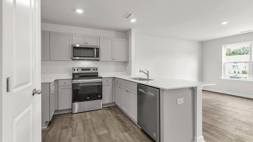 kitchen with quartz counters, kitchen peninsula,  pantry, stainless steel appliances