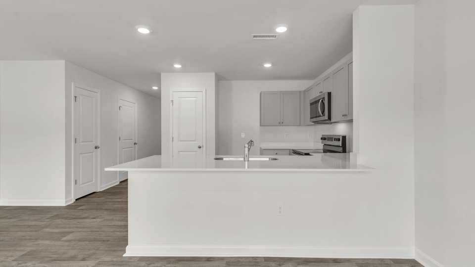 kitchen with quartz counters, kitchen peninsula,  pantry, stainless steel appliances