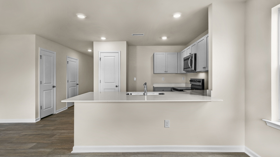 kitchen with quartz counters, kitchen island, pantry, stainless steel appliances
