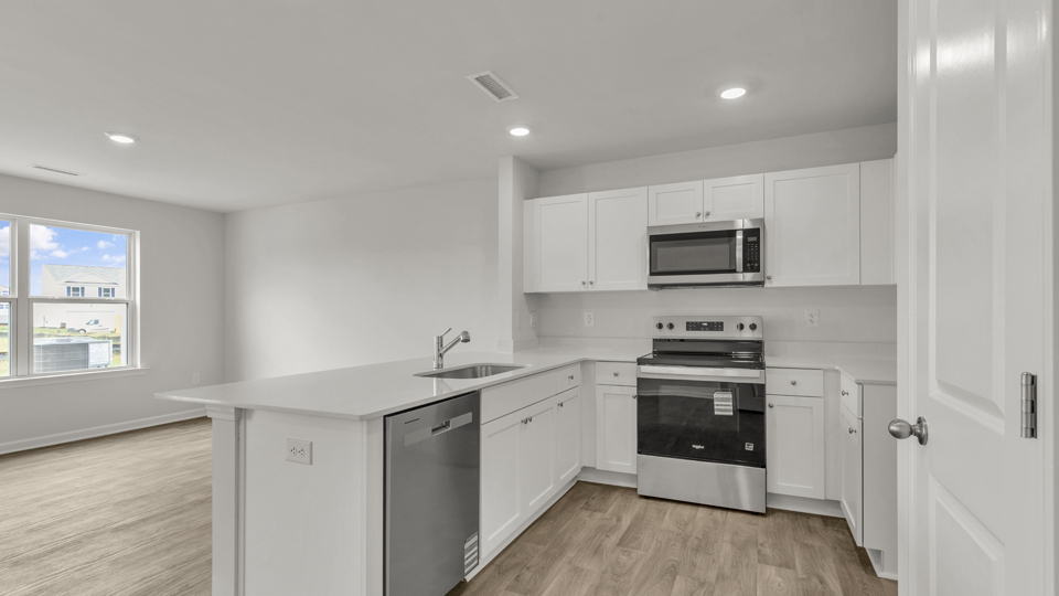 kitchen with quartz counters, kitchen peninsula,  pantry, stainless steel appliances