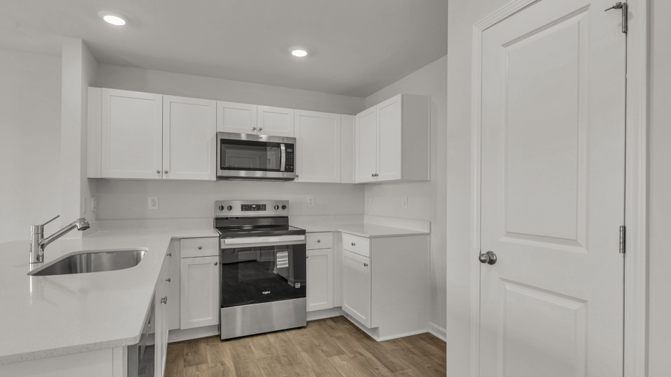 kitchen with quartz counters, kitchen peninsula,  pantry, stainless steel appliances