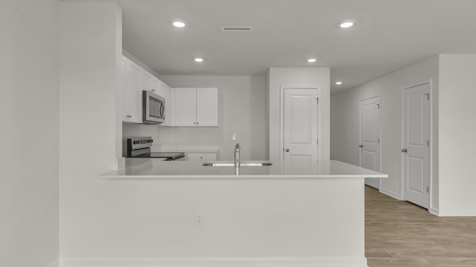 kitchen with quartz counters, kitchen peninsula,  pantry, stainless steel appliances