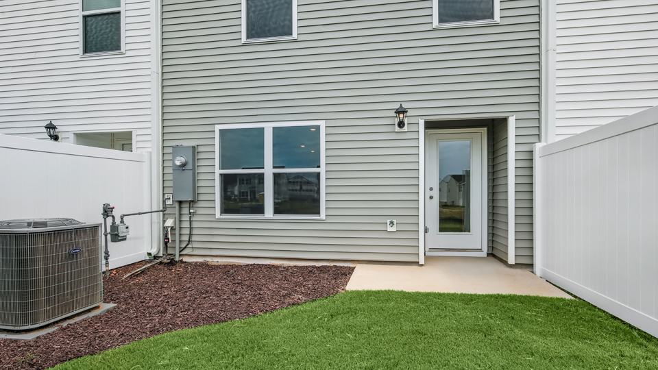 back patio with concrete slab and green yard