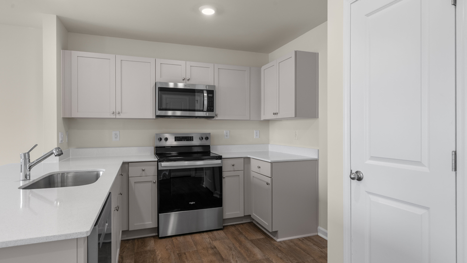open floorplan kitchen with quartz counters,pantry, stainless steel appliances
