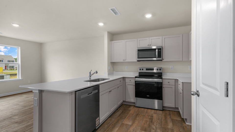 open floorplan kitchen with quartz counters,pantry, stainless steel appliances