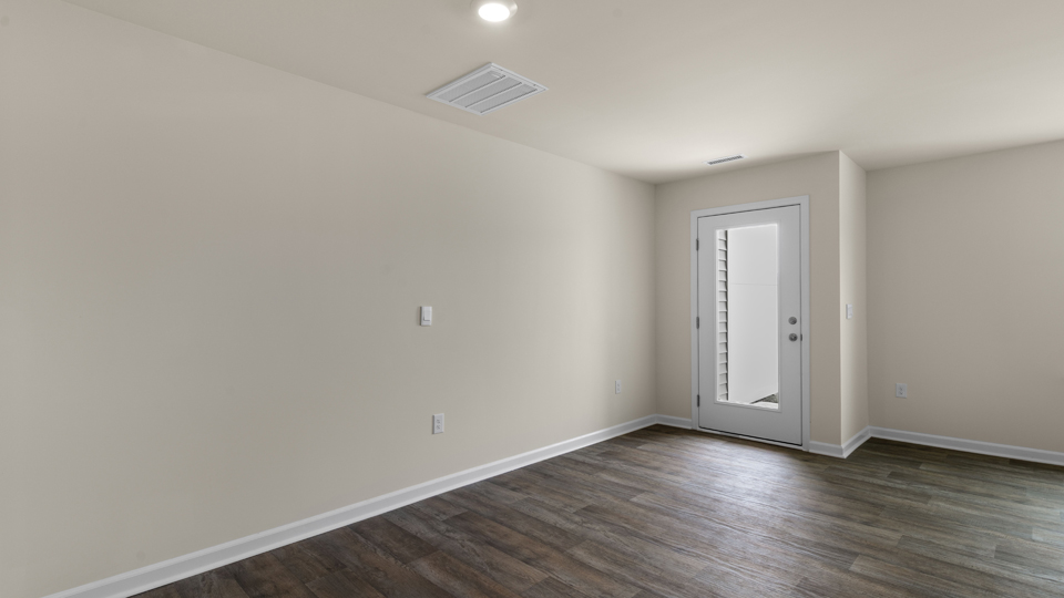 open floorplan living and dining room with lvp flooring, door to patio with concrete slab