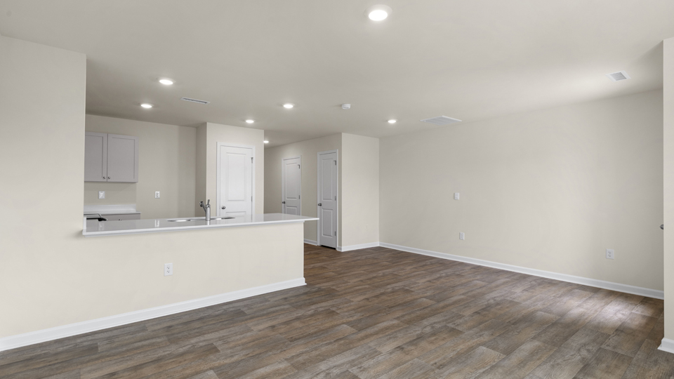 open floorplan living and dining room with lvp flooring, door to patio with concrete slab