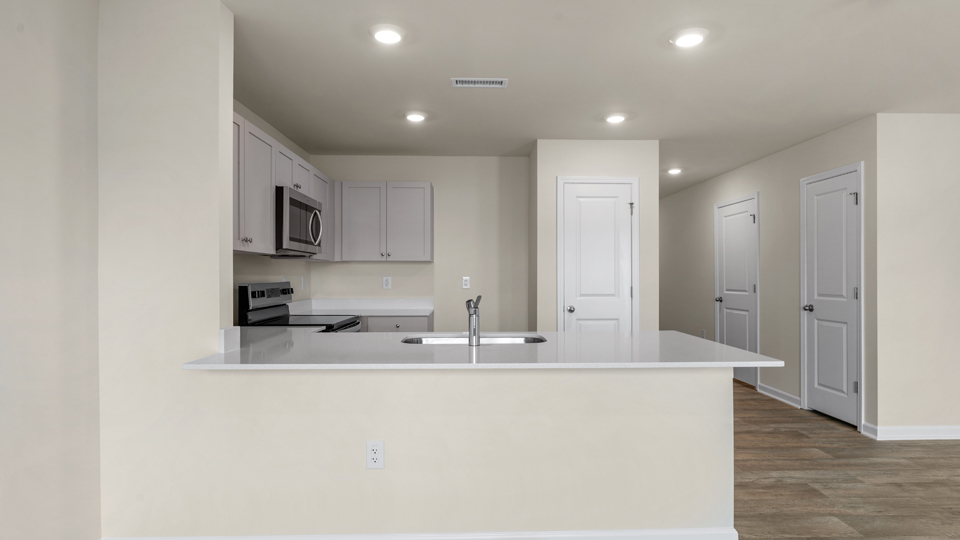 open floorplan kitchen with quartz counters,pantry, stainless steel appliances