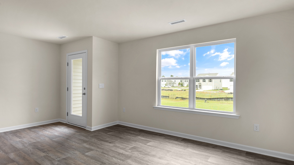 open floorplan living and dining room with lvp flooring, door to patio with concrete slab